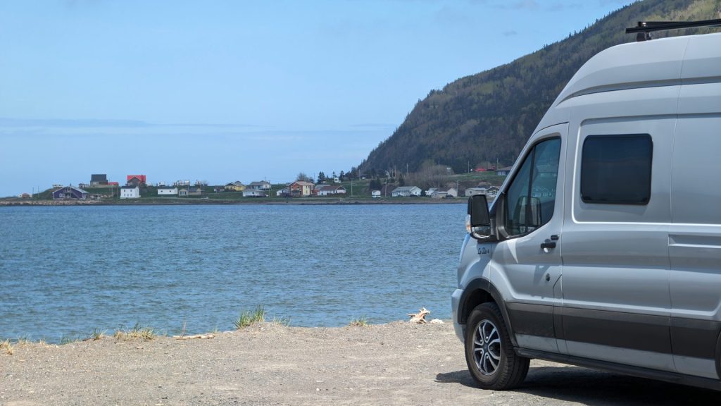 a van parked next to a body of water
